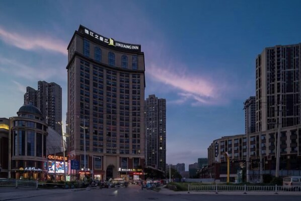 A high-rise hotel with a prominent sign, surrounded by other buildings and a clear sky.