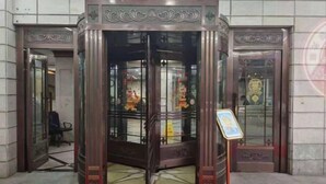 A revolving door with glass panels and decorative metalwork. - Shanghai Jiu Yu Hotel (Shanghai)