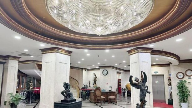 A lobby with a grand chandelier, marble columns, and statues. - Shanghai Jiu Yu Hotel (Shanghai)