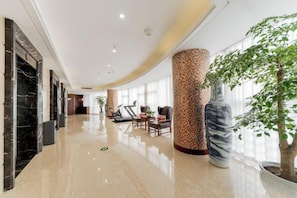 A hotel lobby with a marble reception desk, seating area, and a large column. - Yangzhong Zhonghai Hotel (Yangzhong)