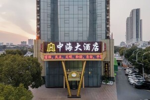 Un hotel con un letrero llamativo, una fachada de edificio moderna y vistas de la ciudad circundante.