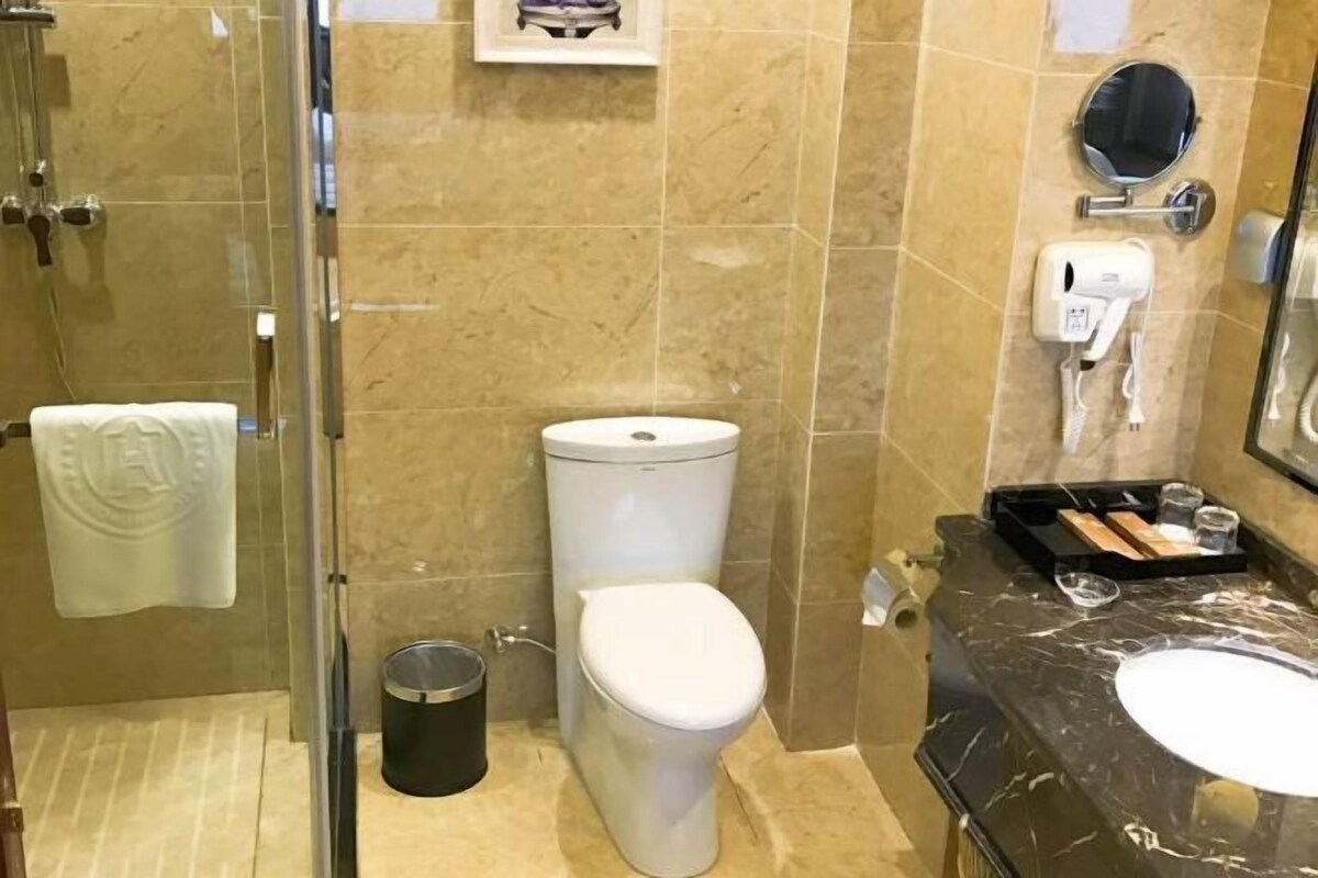 Ein Badezimmer mit Toilette, Waschbecken und einer Duschkabine aus Glas.