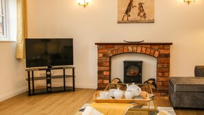 Sala de estar com televisão, lareira e área de estar.