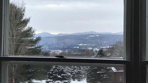 A view from a window with a clear sky and distant mountains. - Spectacular views and close to three ski areas; Stowe, Smuggler’s  and Jay Peak. (Hyde Park)