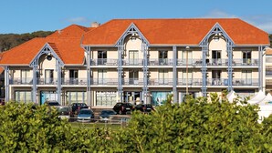 A multi-story hotel with a red-tiled roof and balconies.