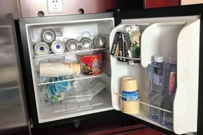 Un refrigerador abierto con diversos alimentos y bebidas.