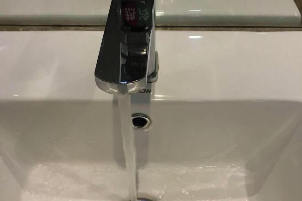 Un lavamanos blanco con grifo cromado y desagüe visible.