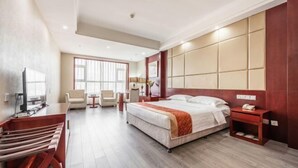 A hotel room with a bed, bedside table, chair, desk, TV, and a large window. - Jinyuan Hotel (Hui County)
