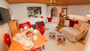 A cozy, compact living space with a dining area, a sofa, and a kitchen.