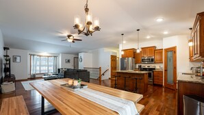 Una cocina amplia con gabinetes de madera, electrodomésticos de acero inoxidable y una isla central.