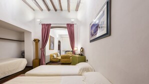 A hotel room with two beds, a yellow armchair, a green cabinet, and a framed picture on the wall. - Velluti apartment for rent by Mmega (Florence)
