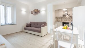 Eine moderne Wohnung mit Wohnbereich, Küchenzeile und Essbereich.