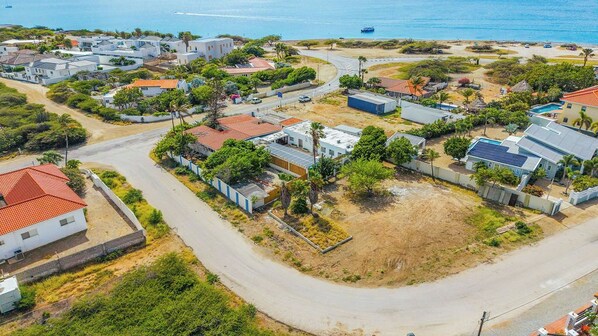 An aerial view of a coastal residential area with houses, roads, and a beach. - Villa Allegra ~ Family Vacation Home w/ Pool & BBQ (Noord)