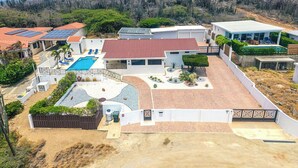 A residential property with a swimming pool, solar panels, and a view of a hilly landscape. - Breathtaking Views 2BR3BA Private Pool Large Space (Noord)