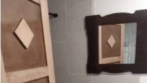 A bathroom with a white sink, a mirror with a wooden frame, and a door with a geometric pattern. - Studio independiente (Ensenada)