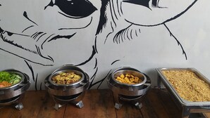 Un buffet avec différents plats présentés dans des récipients en métal.