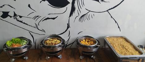 A buffet setup with various food items in metal containers.