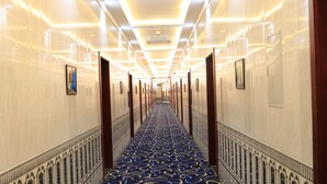 A long, narrow hallway with a patterned carpet and mirrored walls. - Pearl Of Vision Hotel (Jeddah)