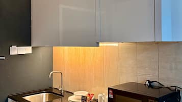 Een moderne keuken met een zwart aanrecht, een roestvrijstalen spoelbak en een magnetron.