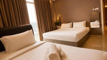Quarto de hotel com duas camas, uma janela grande com cortinas, mesa de cabeceira com abajur e um espelho.