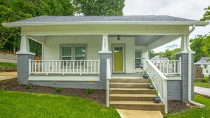 A single-story house with a covered porch, a front door, and a set of stairs leading to the entrance. - 2 bedrooms, 1 bath, cozy kitchen, living room and game room/ multipurpose room. (Chattanooga)