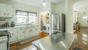 A modern kitchen with white cabinets, a stainless steel refrigerator, and a built-in washing machine. - 2 bedrooms, 1 bath, cozy kitchen, living room and game room/ multipurpose room. (Chattanooga)