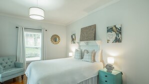 A bedroom with a bed, a nightstand, a chair, and artwork on the walls. - 2 bedrooms, 1 bath, cozy kitchen, living room and game room/ multipurpose room. (Chattanooga)