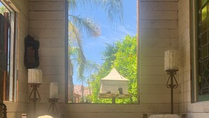 Una habitación acogedora con dos sillones cómodos, una pequeña mesa redonda y una ventana con vistas a zonas verdes.