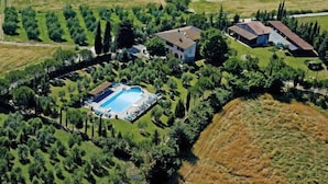 An aerial view of a property with a swimming pool, multiple buildings, and surrounding greenery. - Apartment Rosa by Interhome (Peccioli)