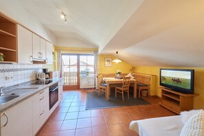 Una cocina compacta con comedor, televisor y un espacio de estar acogedor.
