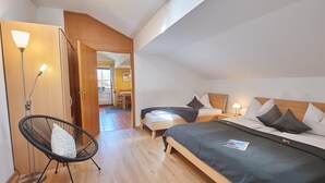 A bedroom with a bed, bedside tables, a chair, and a lamp. - Type D Apartment Waginger See 2nd floor 50 sqm up to 3 persons, 1 bedroom, balcony (Piding)