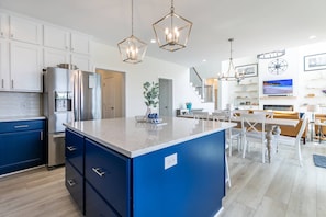 A modern kitchen with blue cabinets, stainless steel appliances, and a central island.