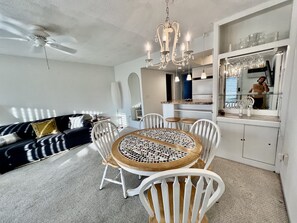 A modern kitchen with white cabinets, a dining area with a mosaic table, and a ceiling fan. - Apartment in Pompano, just a few minutes from the beach   (Pompano Beach)