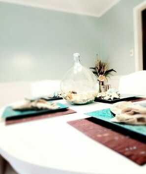 A round table with a clear glass bottle containing pebbles, a small potted plant, and a few decorative items.