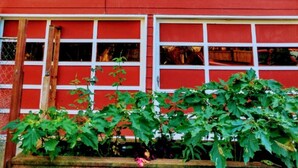 A red barn with a white window and garage door. - The Hideout (Crescent City)