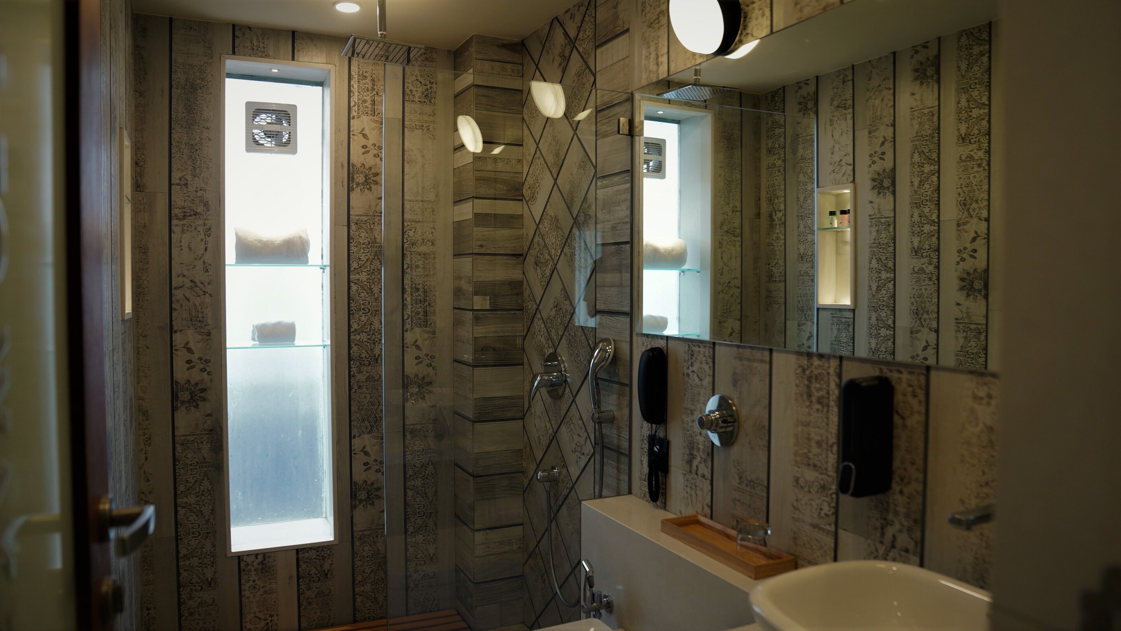 A bathroom with a large mirror, a bathtub, and a shower with a glass door.