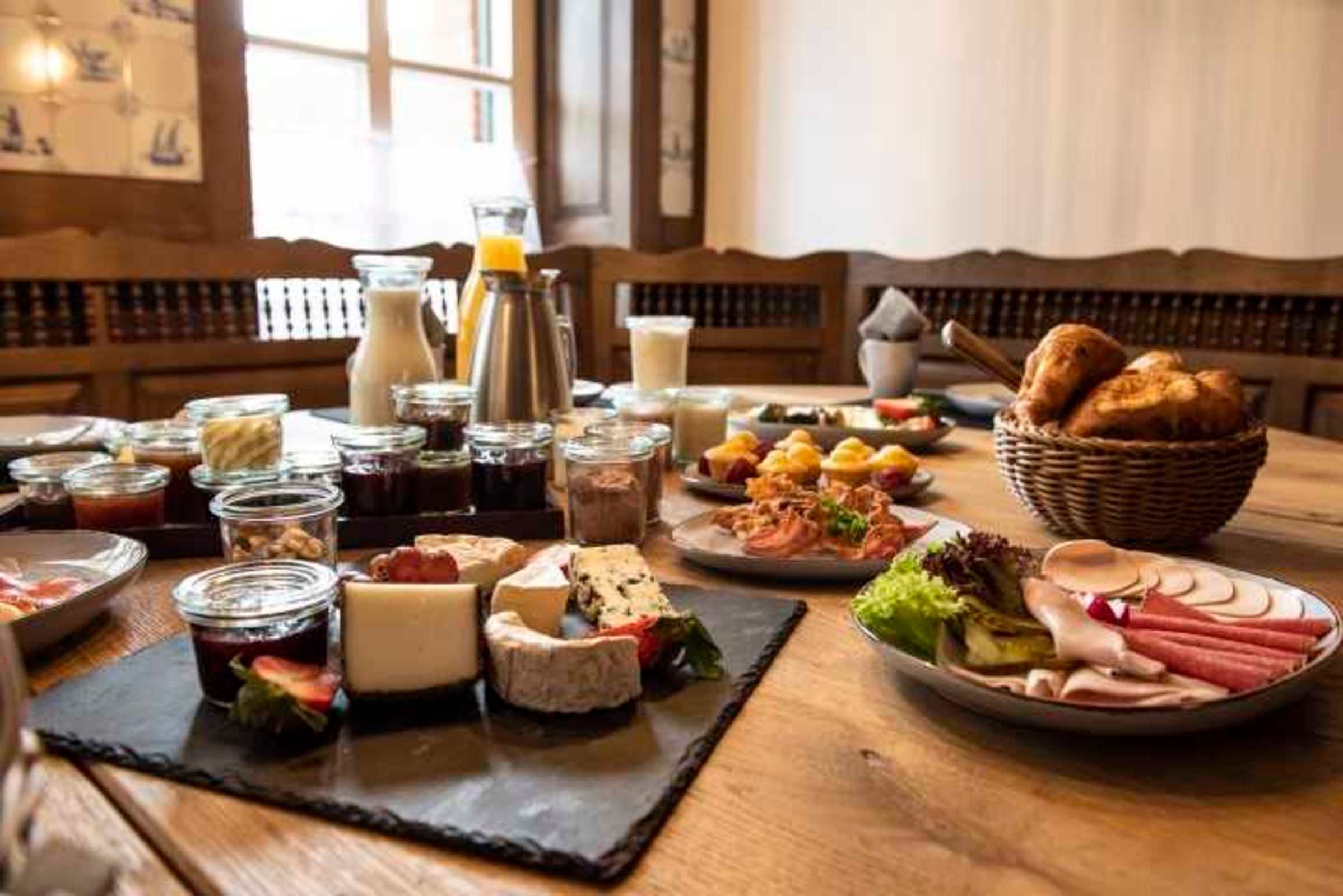 Ein Frühstücksbuffet mit verschiedenen Käsesorten, Fleischwaren und Brotsorten.