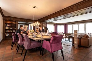 A dining area with a large table, purple chairs, and a chandelier. - Herrenhaus im Artland - Herrenhaus (Ankum)
