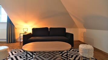 A modern living room with a sofa, coffee table, patterned rug, and a lamp.