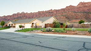 A residential area with houses, a street, and a mountainous backdrop.