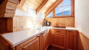 Una cocina de madera con ventana, un lavamanos y armarios.