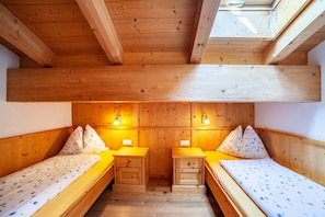 A wooden cabin with two beds, each with a nightstand and a lamp. - Holiday Apartment "Hof am Schloss Zirm" with Mountain View and Wi-Fi (Prad am Stilfserjoch)