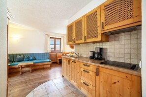 A kitchen with wooden cabinets, a sink, and a coffee maker. - Holiday Apartment "Hof am Schloss Enzian" with Mountain View and Wi-Fi (Prad am Stilfserjoch)