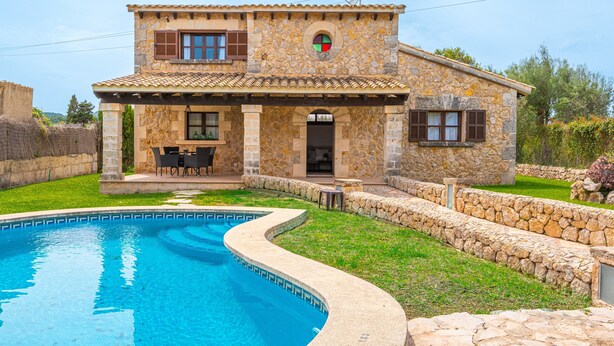 A stone house with a swimming pool, outdoor seating, and a stone wall. - Villa "Pau" with Mountain View, Pool, Wi-Fi & Terraces (Alcudia)