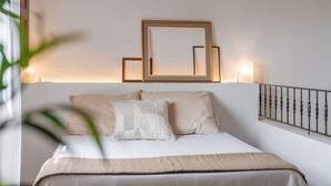 A neatly made bed with a headboard, bedside lamps, and a mirror. - Villa "Pau" with Mountain View, Pool, Wi-Fi & Terraces (Alcudia)