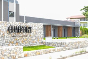 A modern building with a stone facade and the name "COMFORT" prominently displayed. - Comfort Suites and Rooms (Larissa)