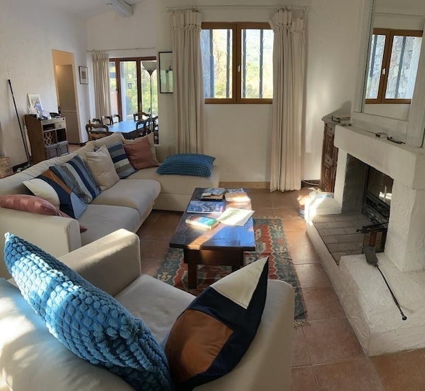 Un salon avec un canapé, une table basse et une cheminée.