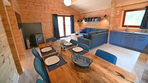 A cozy cabin interior with a dining area, sofa, and kitchenette.