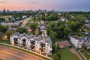 Un quartier résidentiel avec des maisons modernes, une rue principale et, au loin, le profil de la ville.