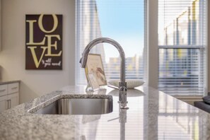 Enjoy cooking in this well-equipped kitchen with a granite countertop and stainless steel faucet.